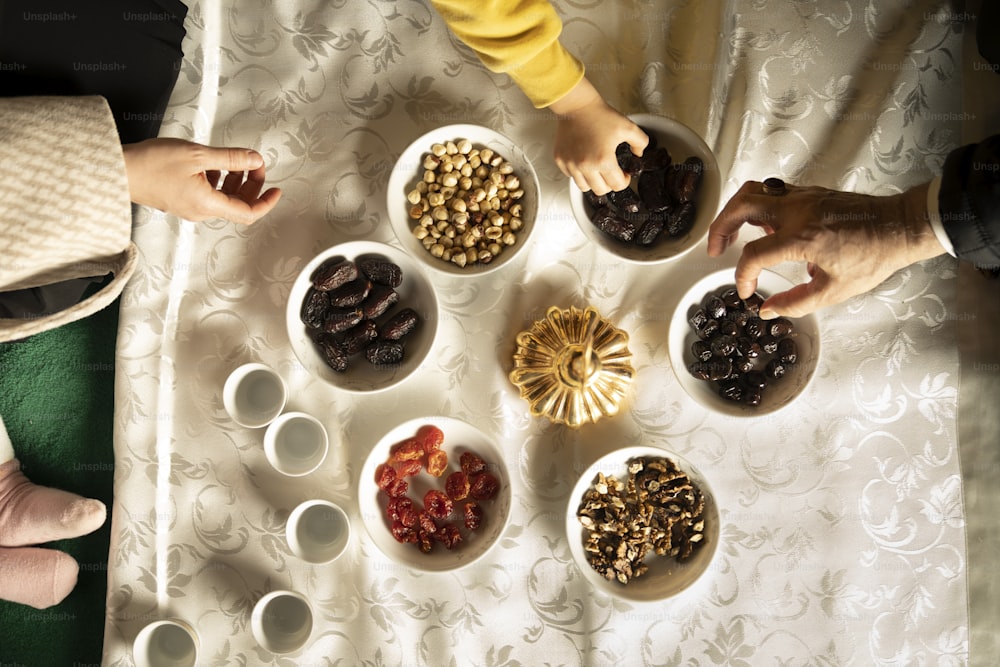 a group of people standing around a table with bowls of food