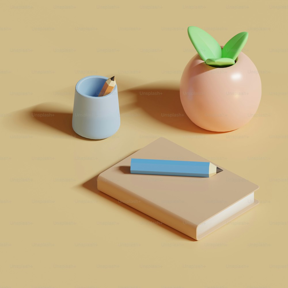 a book, pen, and vase on a table