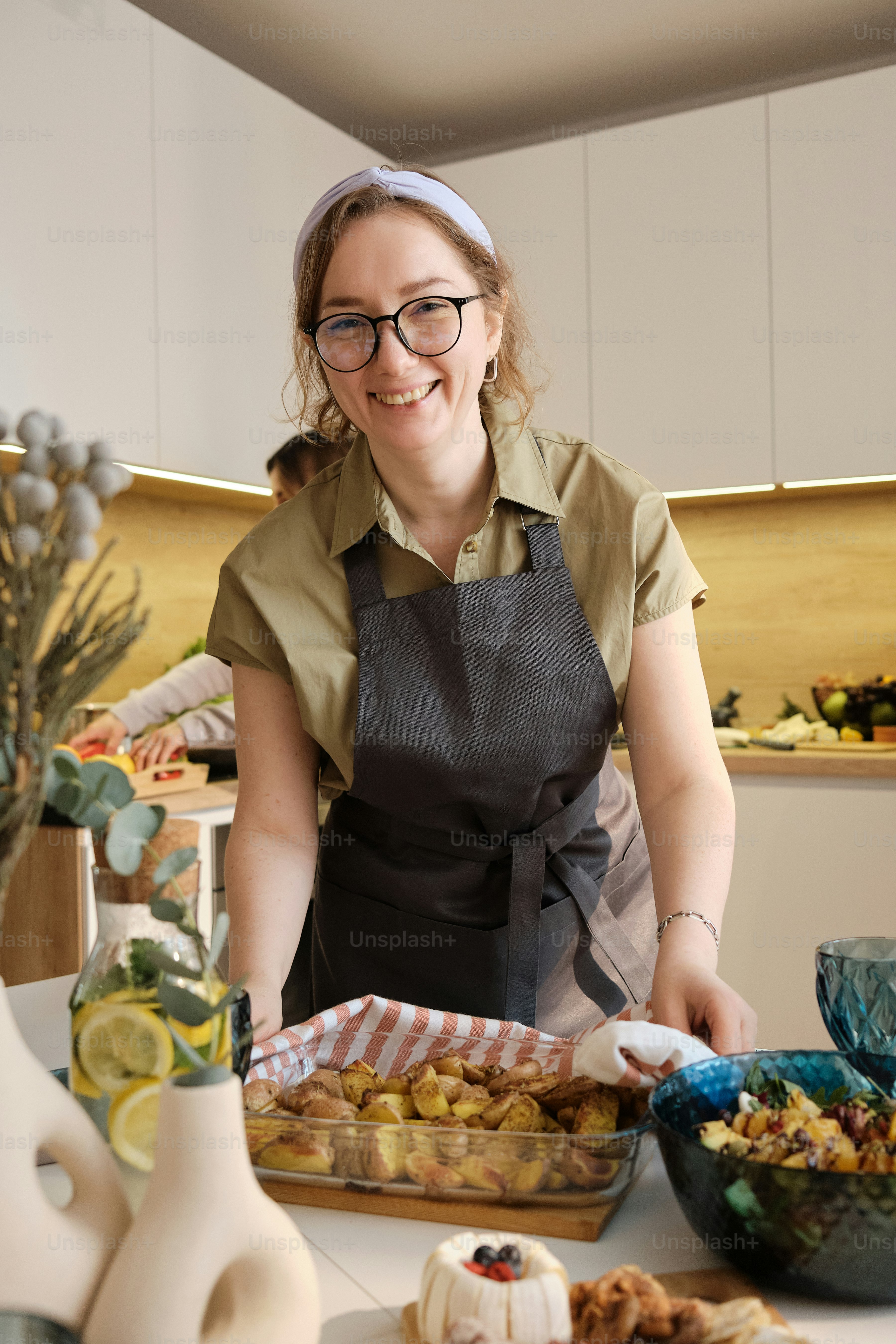 a woman in an apron preparing food in a kitchen