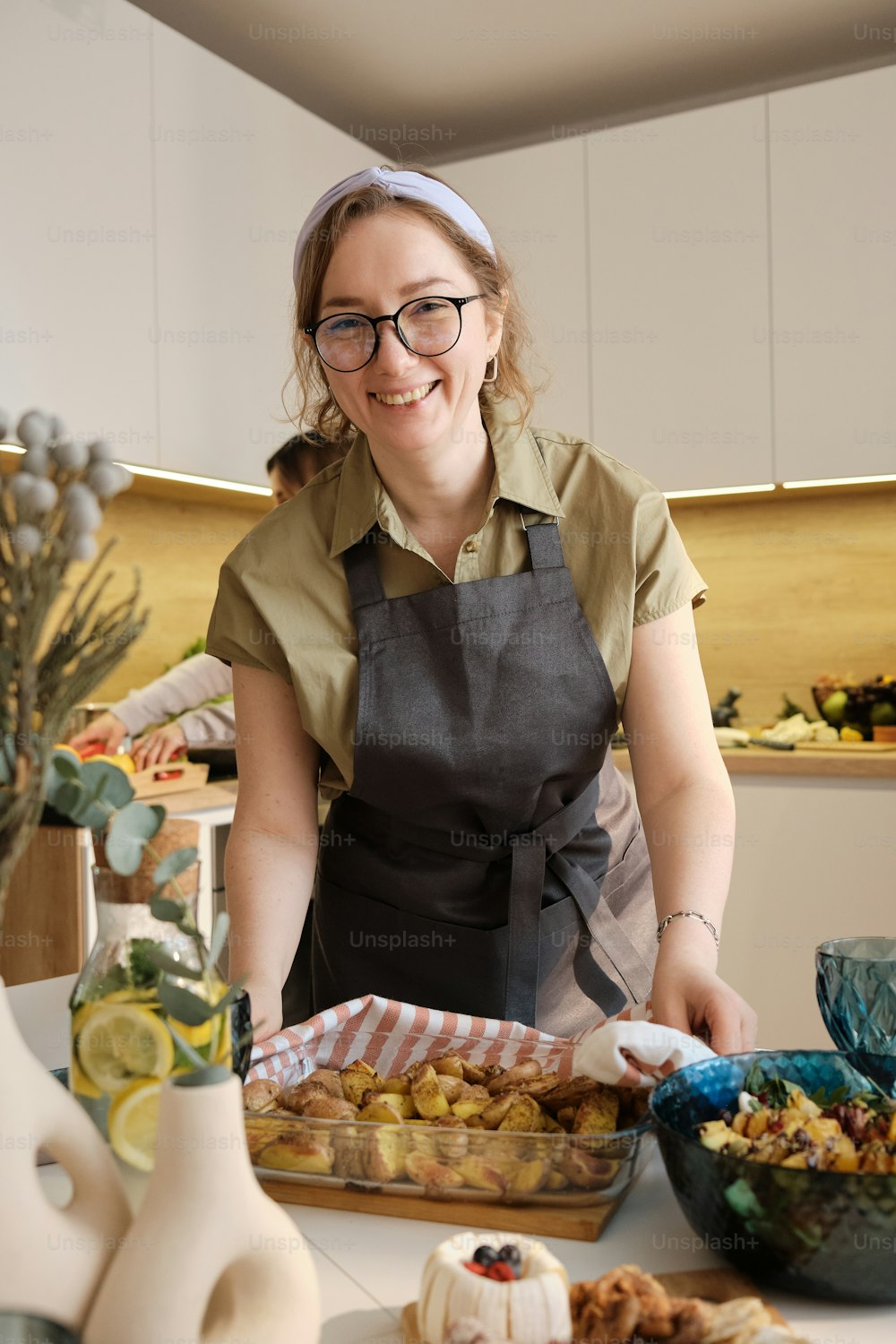 uma mulher em um avental que prepara a comida em uma cozinha