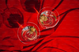 Dos copas de vino tinto sobre un paño rojo