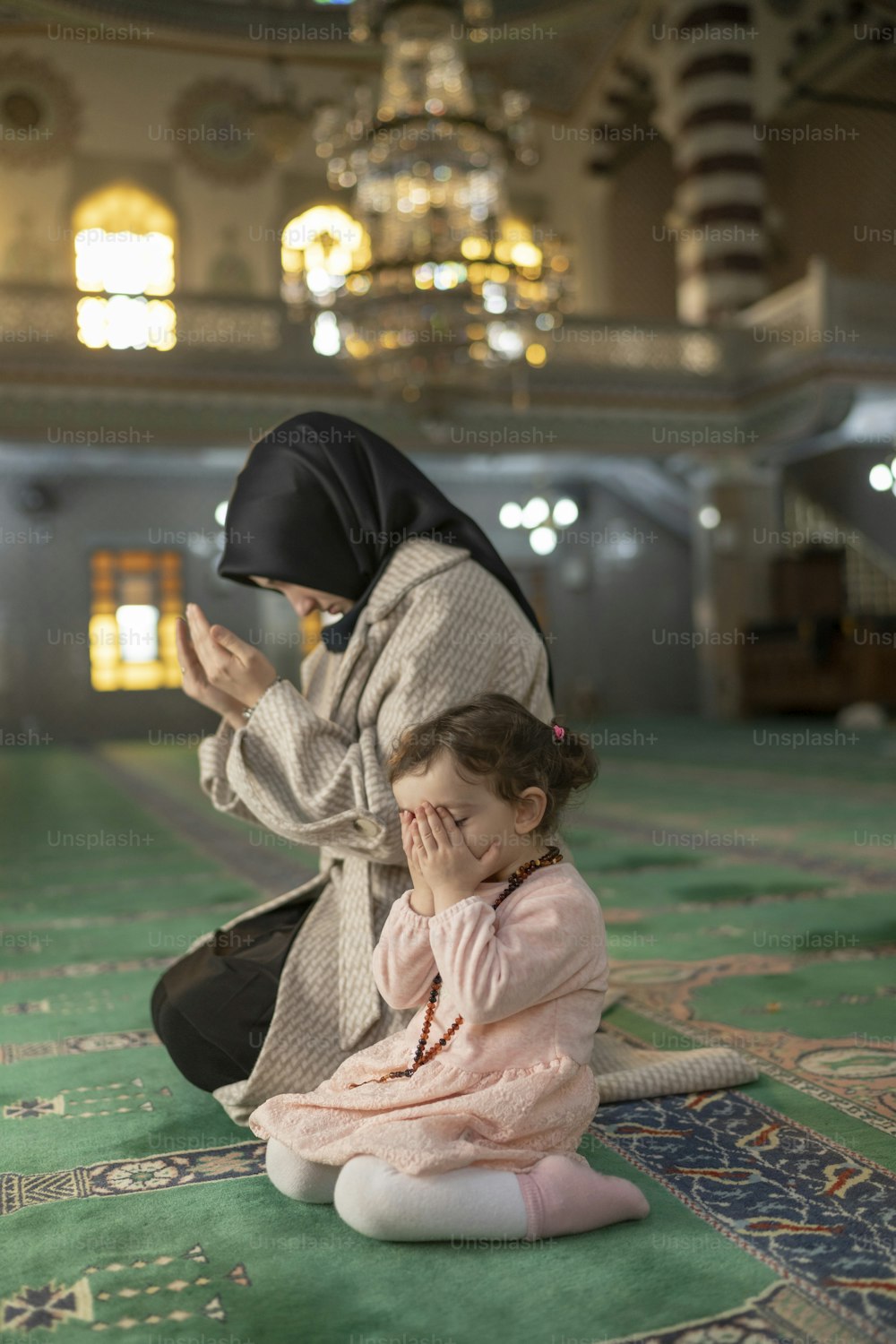 a woman kneeling down next to a little girl