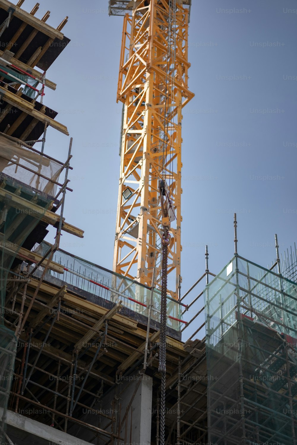 a tall yellow crane sitting on top of a building