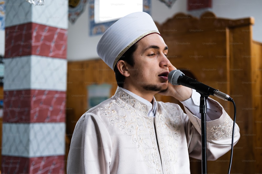 Un uomo in un vestito bianco che canta in un microfono