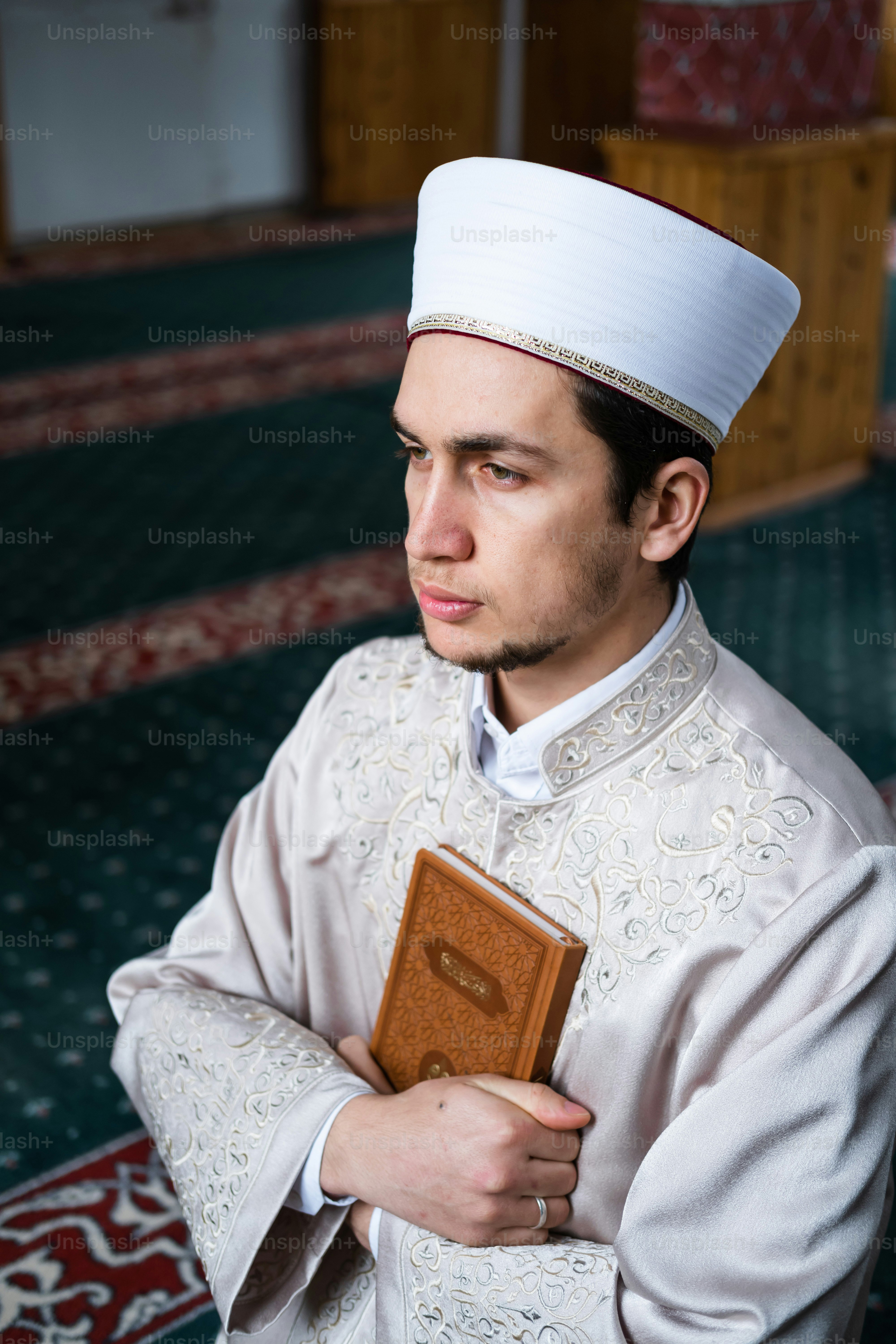 Un homme en tenue blanche tient un livre