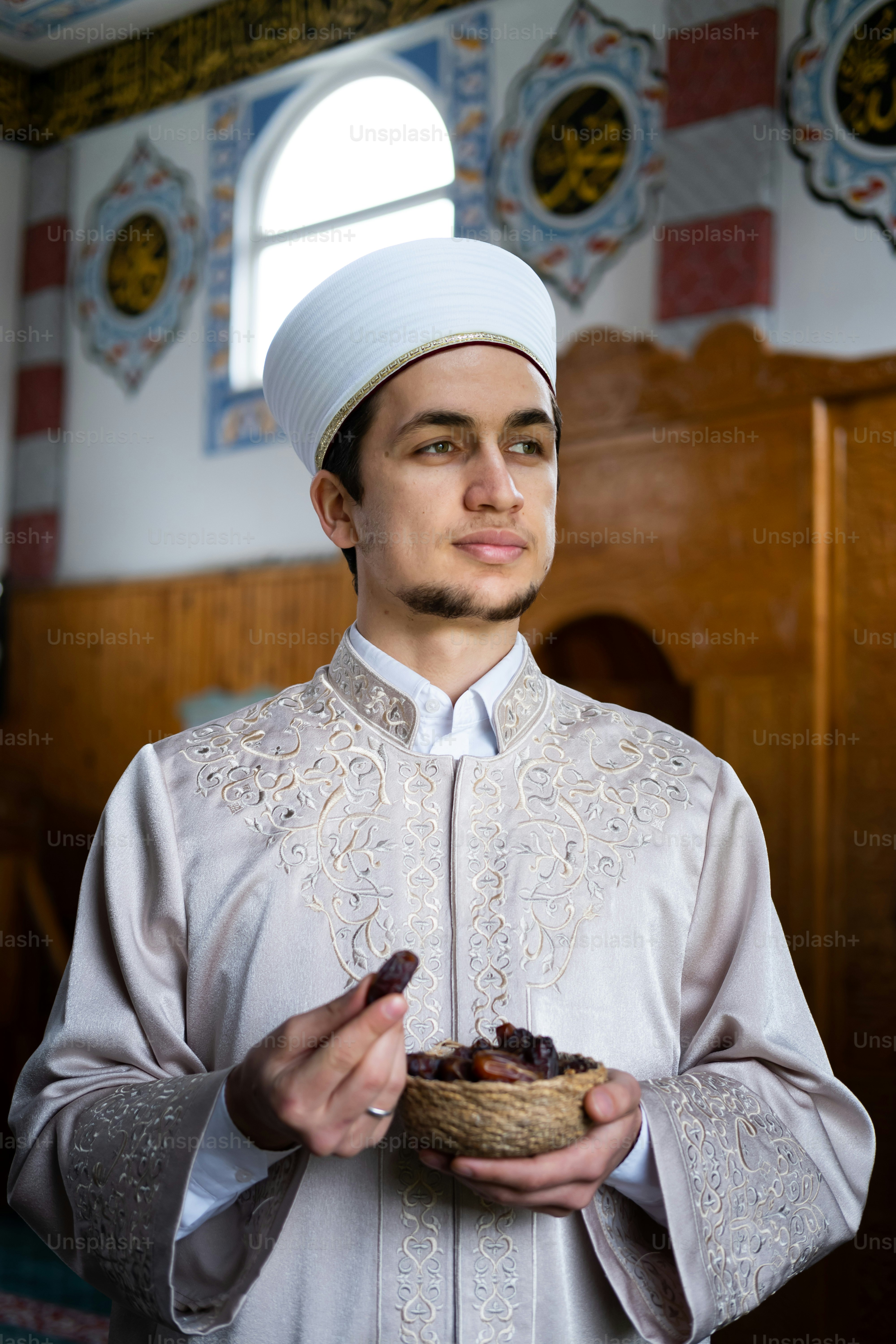 Un hombre con un traje blanco sosteniendo un plato de comida