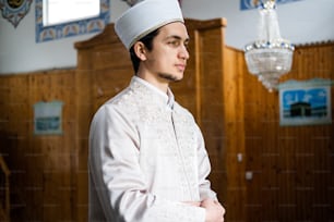 a man in a white outfit standing in a room