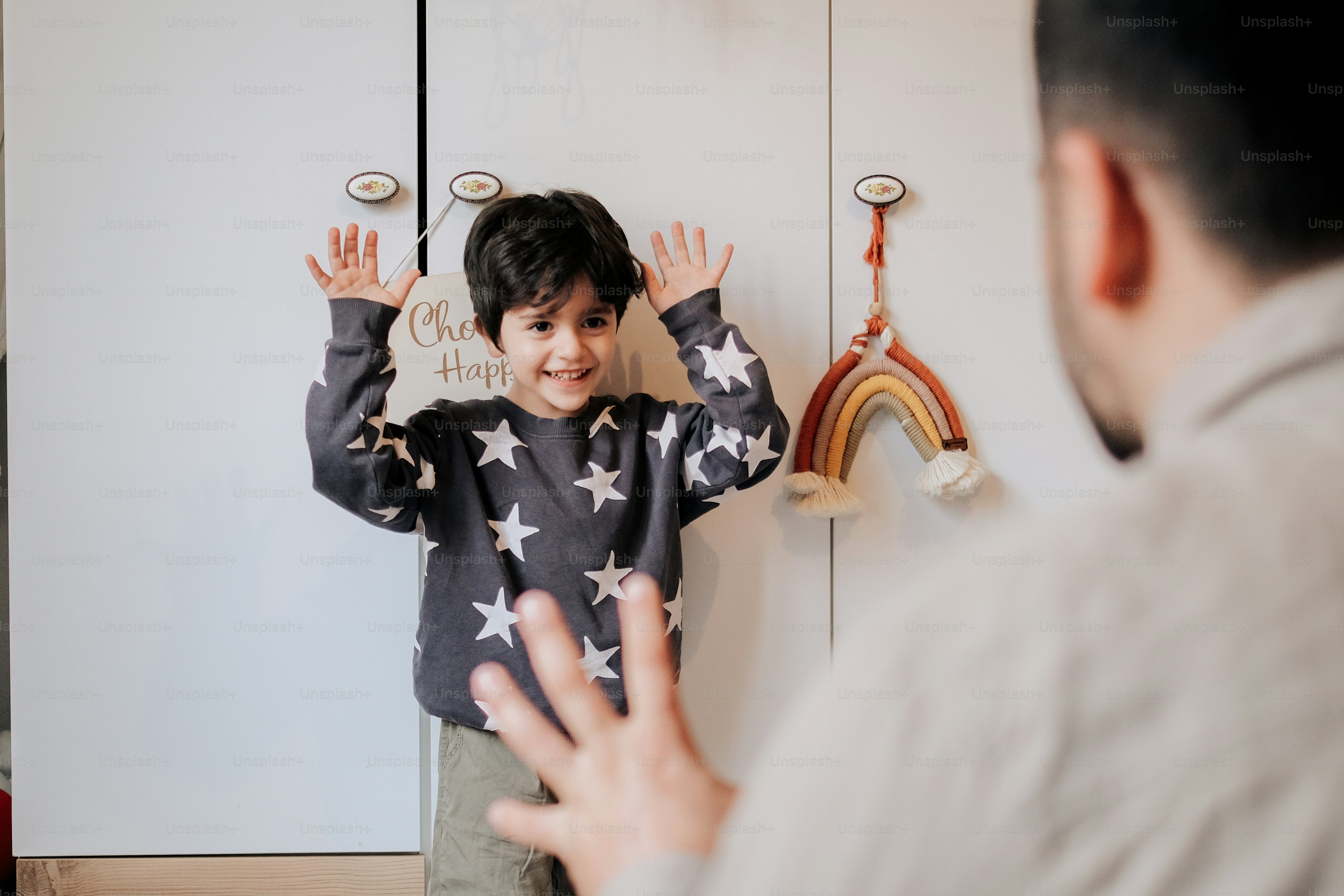 a little boy standing in front of a white refrigerator