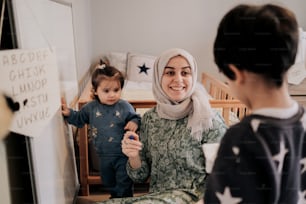 a woman in a hijab holding a baby in a crib
