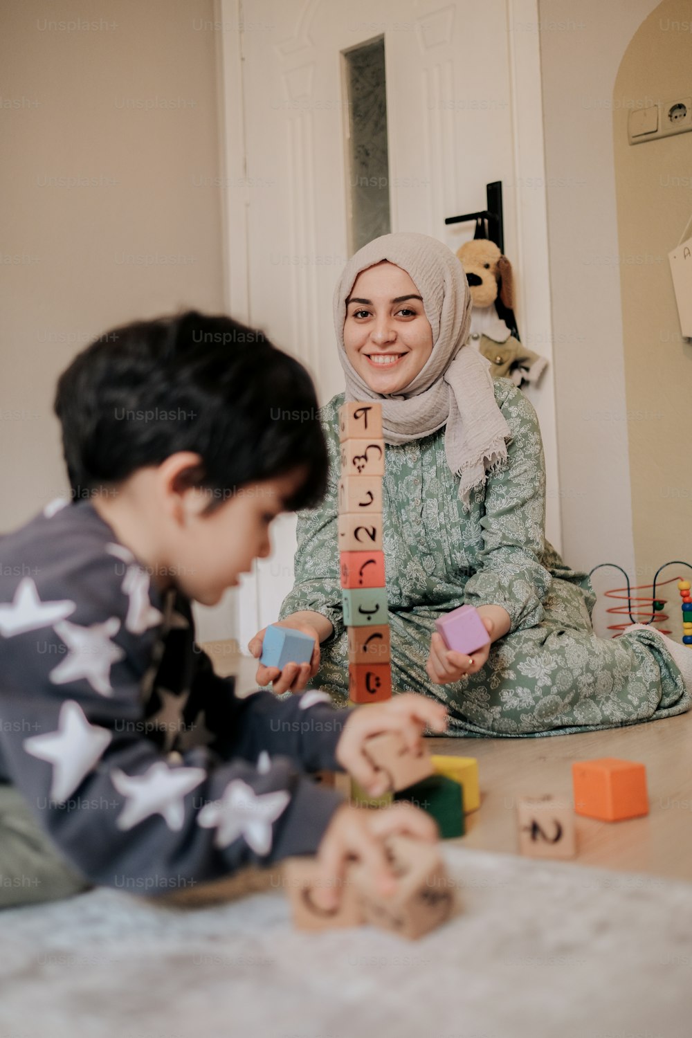 a woman sitting on the floor playing with blocks