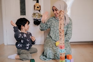 a woman sitting on the floor next to a child