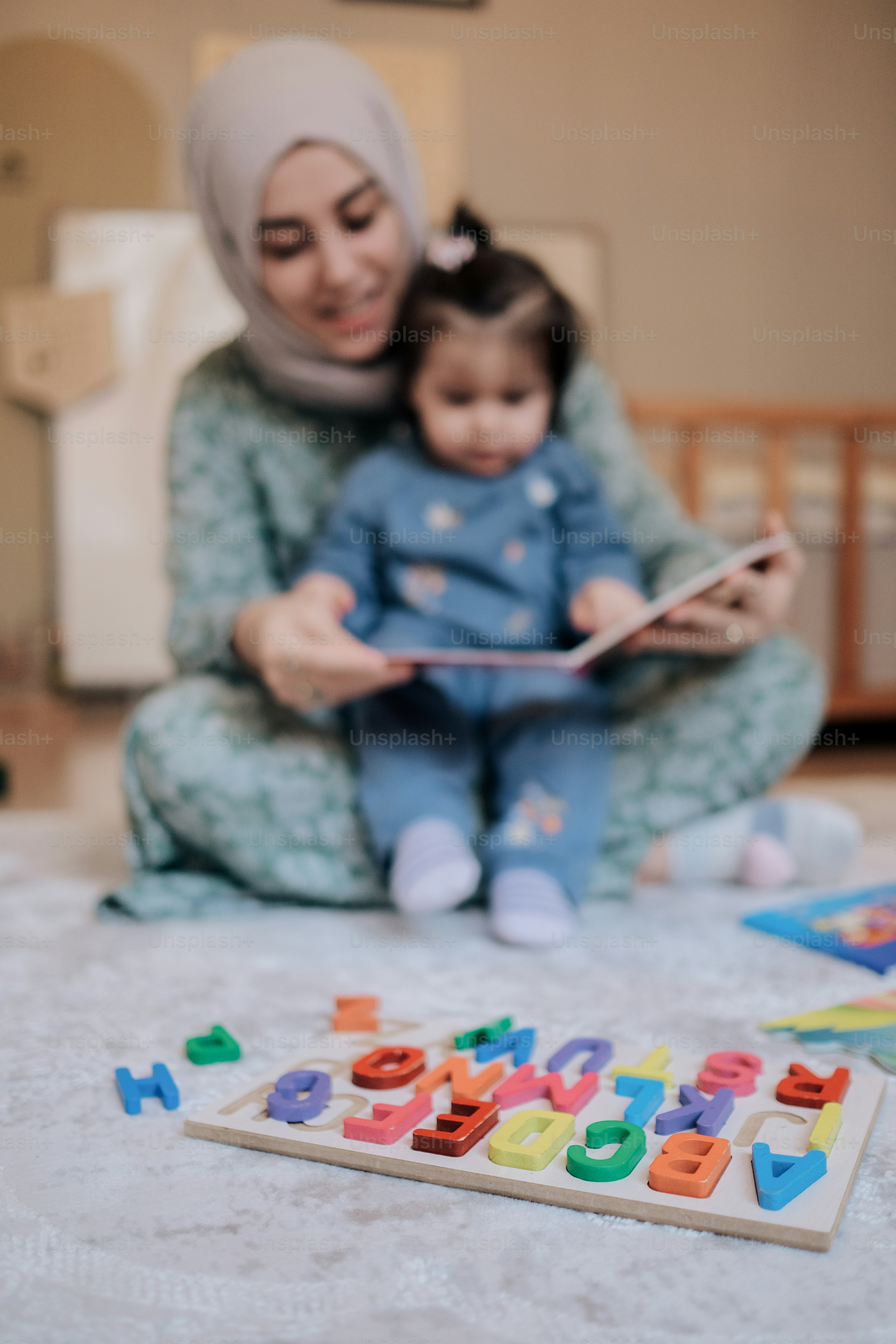 a woman sitting on the floor reading a book to a child