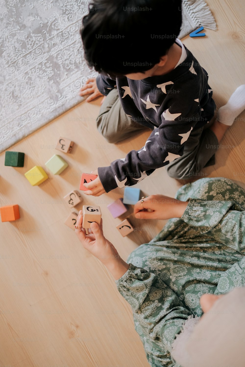 a young boy playing with wooden blocks on the floor