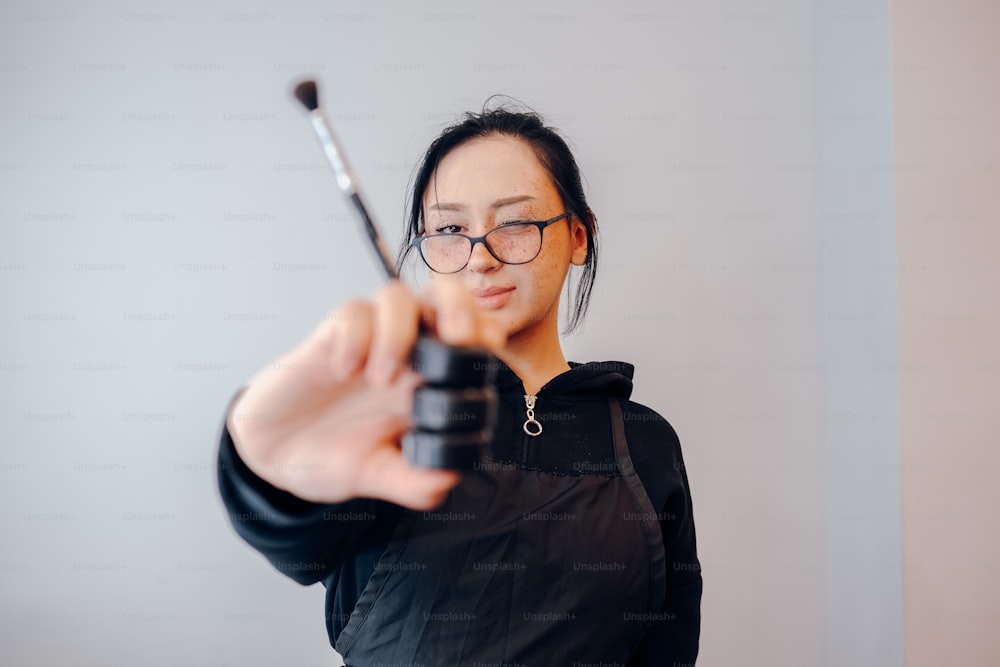 Une femme tenant une arme à feu et la pointant sur la caméra