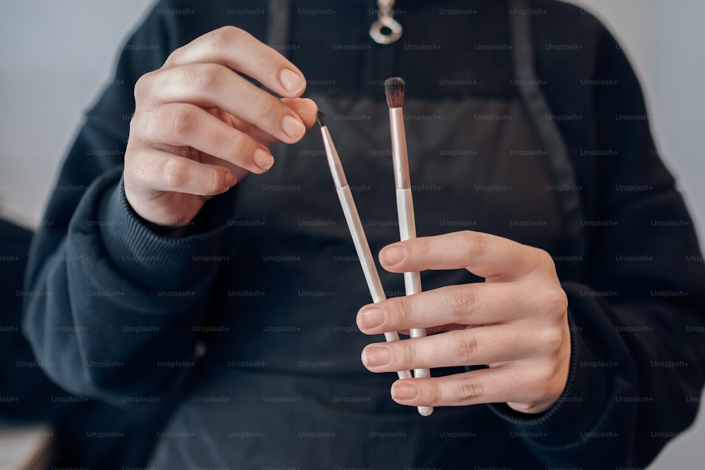 a person holding two brushes in their hands