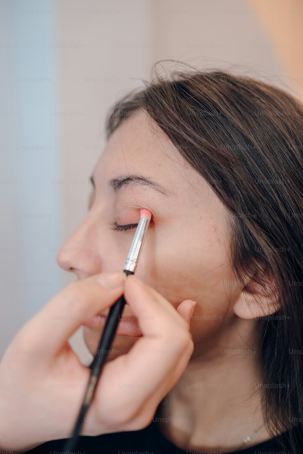 Una mujer se está maquillando la cara