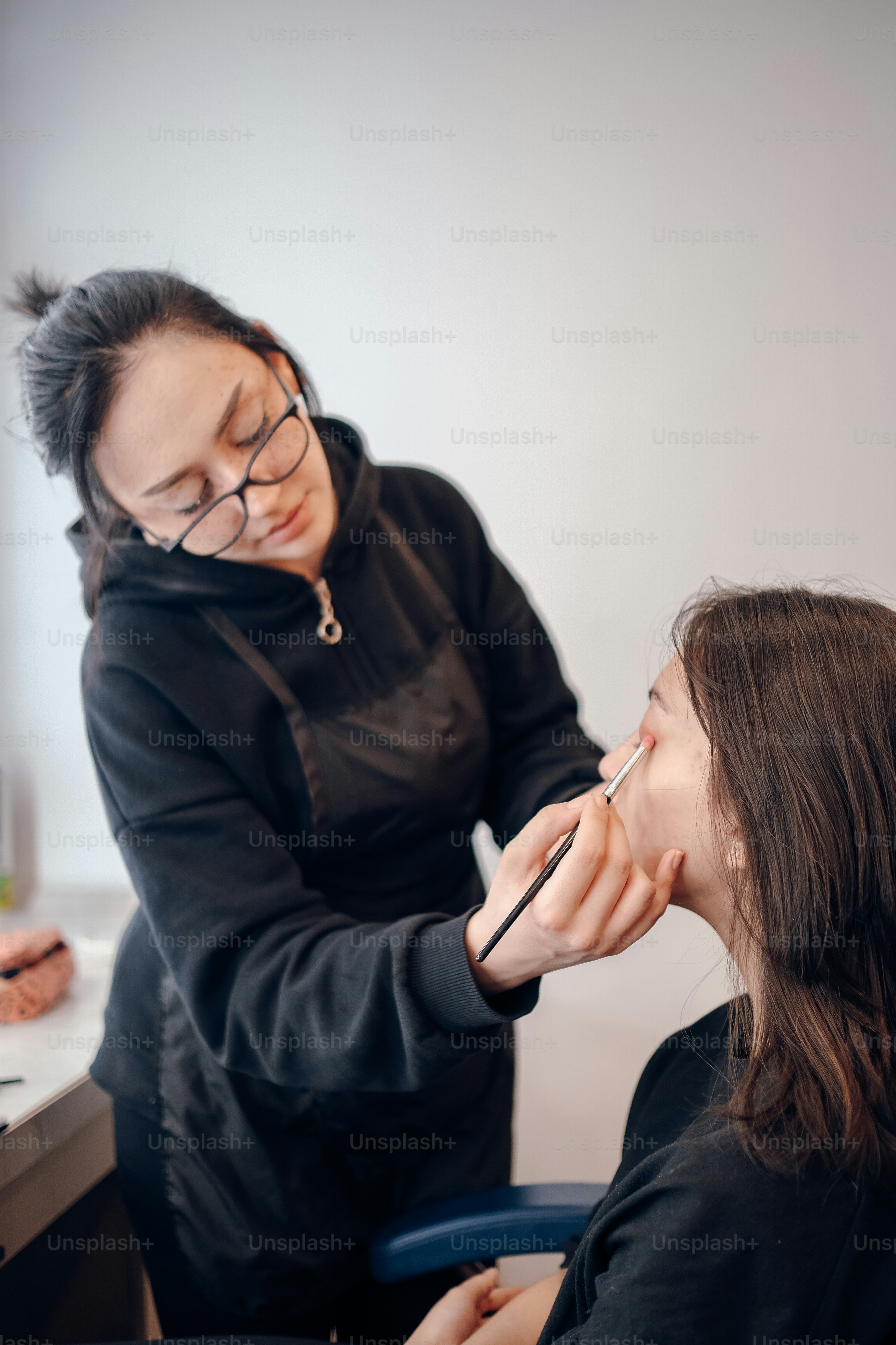 uma mulher sentada em uma cadeira fazendo o cabelo