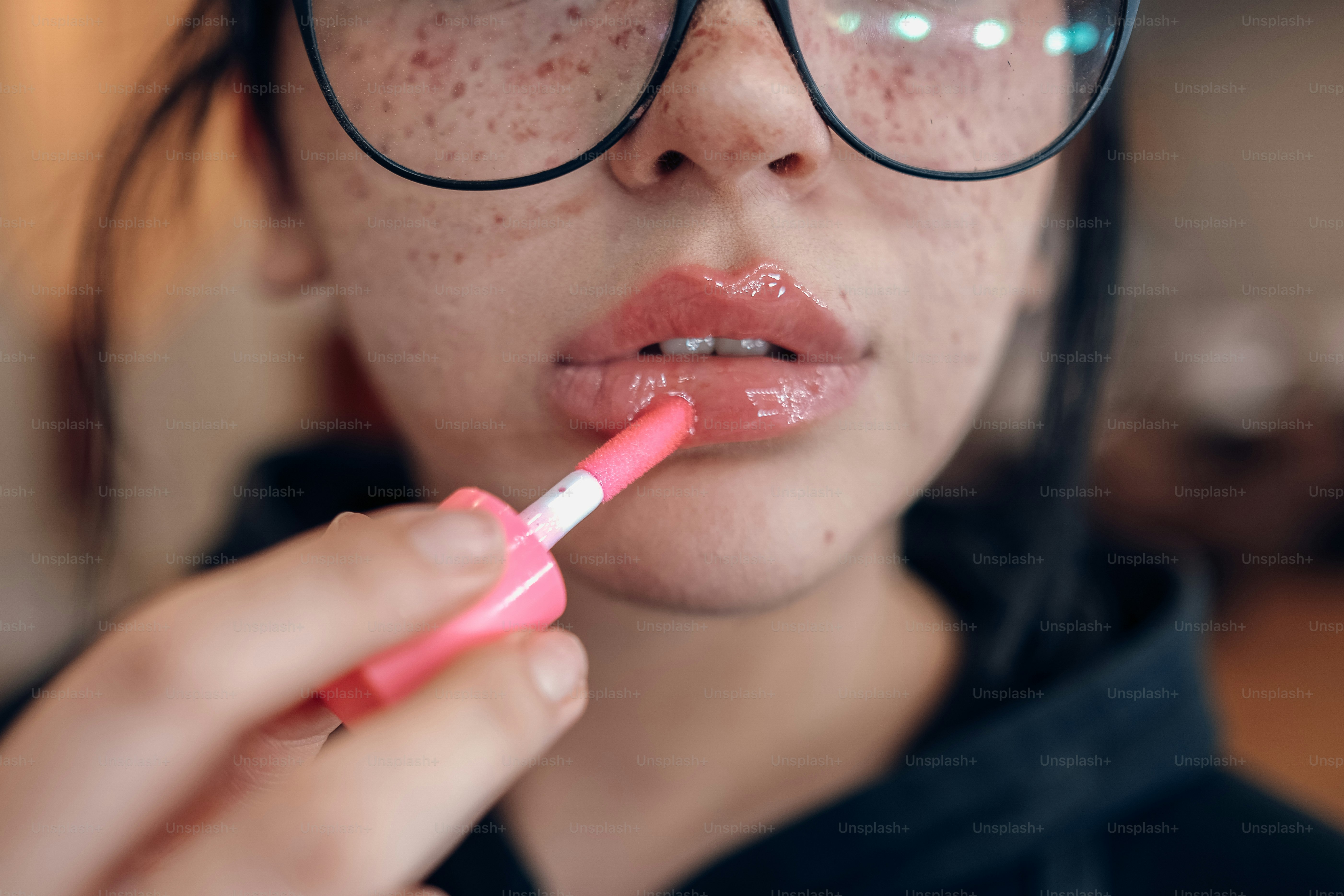 a woman with glasses is brushing her teeth