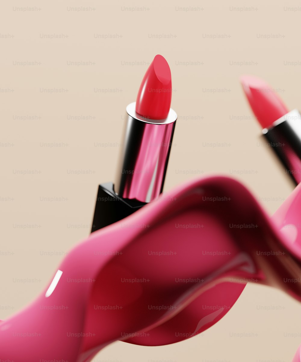 a close up of a lipstick with a pink background