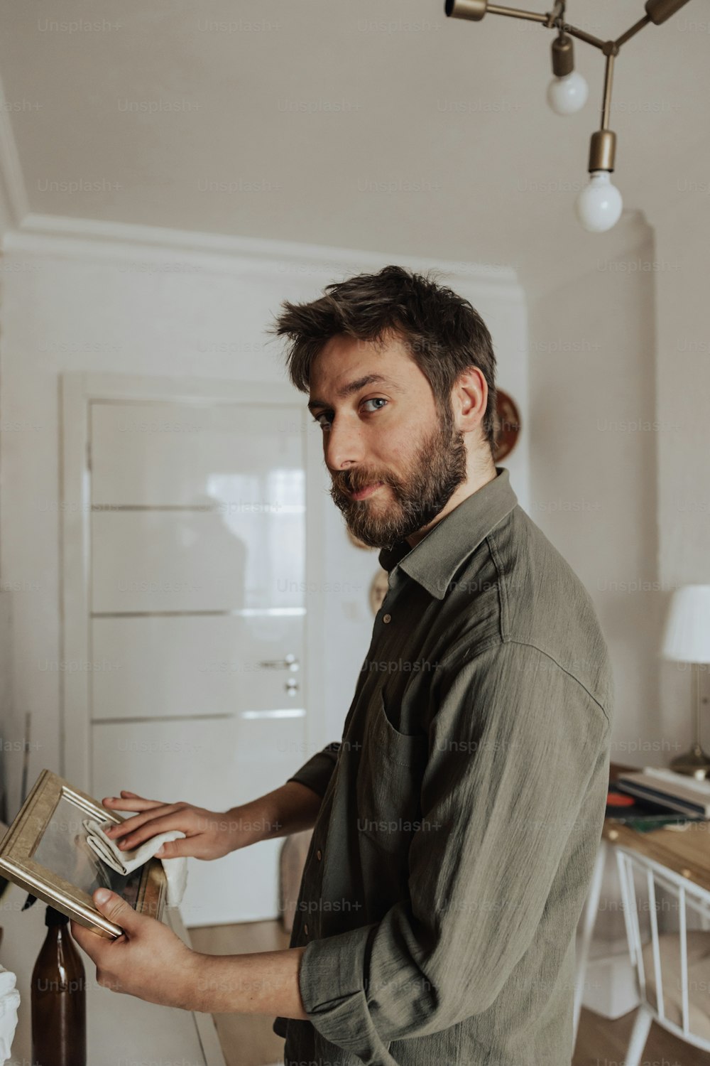 a man standing in a kitchen holding a book