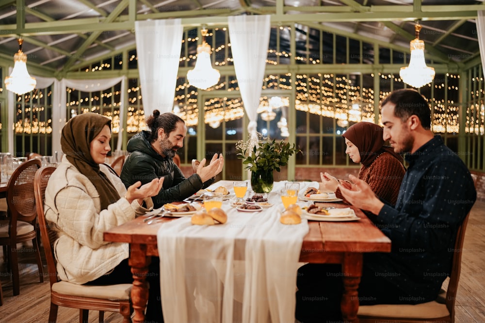 a group of people sitting around a wooden table