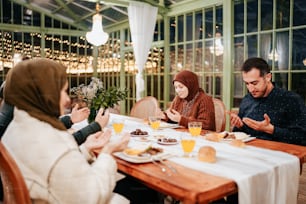 a group of people sitting around a wooden table