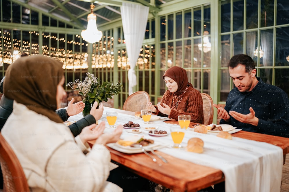 a group of people sitting around a wooden table