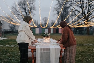 Un couple de femmes debout à côté d’une table