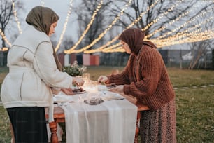 two women sitting at a table with plates of food