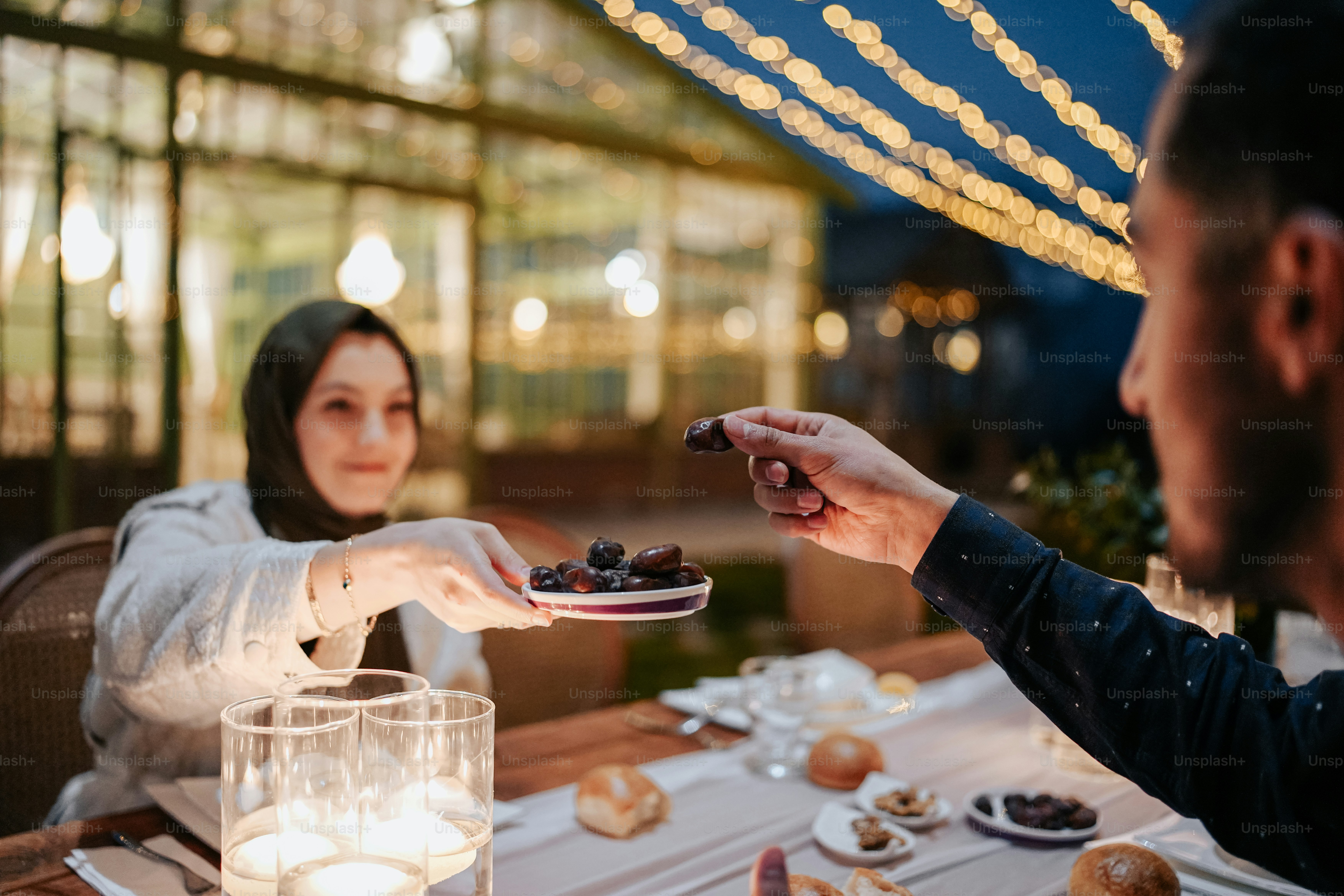 a man handing a plate of food to a woman
