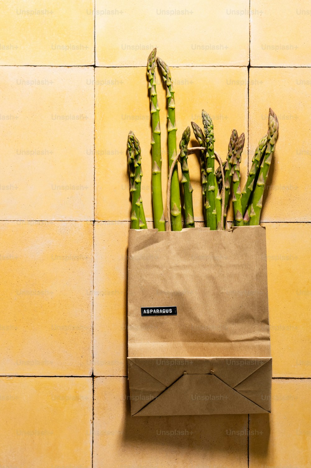 un sac en papier brun contenant des asperges