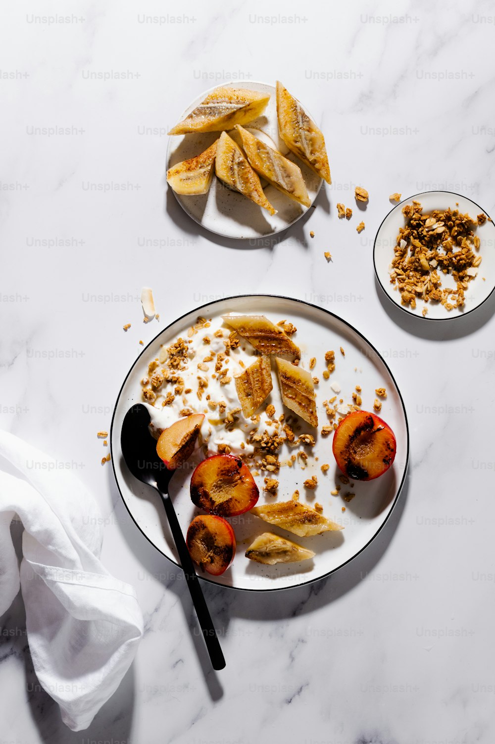 a white plate topped with sliced peaches and granola