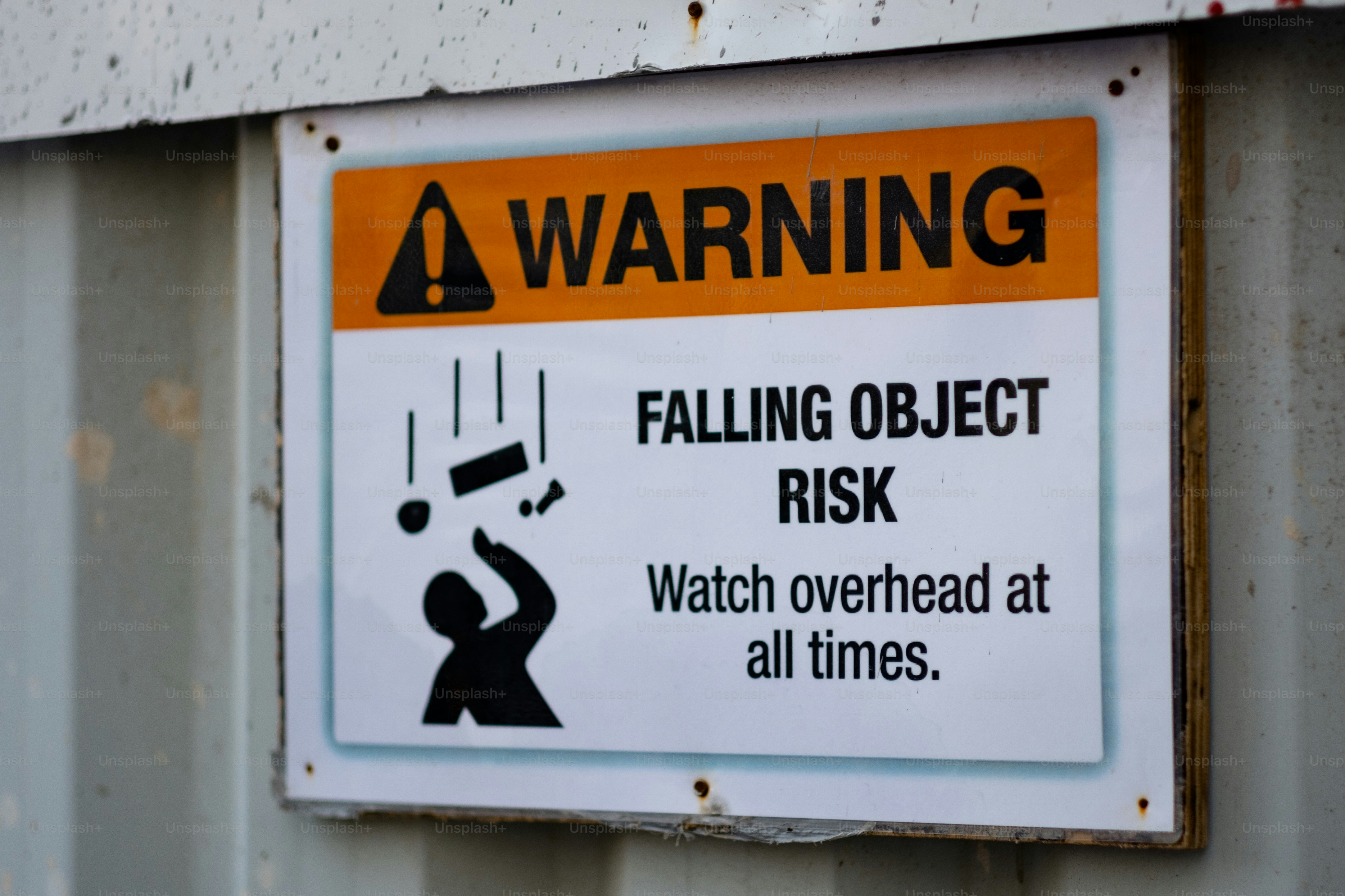 A warning sign at a construction site: falling object risk; watch overhead at all times.