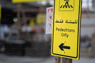 a yellow pedestrian only sign sitting on top of a wooden pole