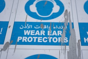 un panneau bleu et blanc qui dit de porter des protecteurs d’oreilles