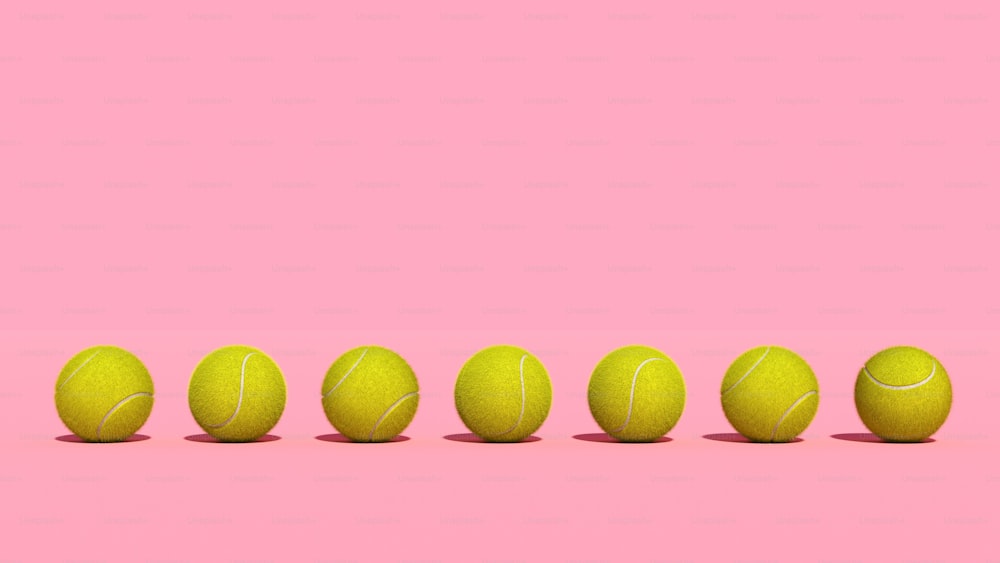 a row of tennis balls on a pink background