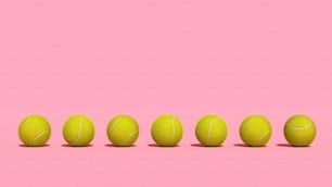 uma fileira de bolas de tênis em um fundo cor-de-rosa