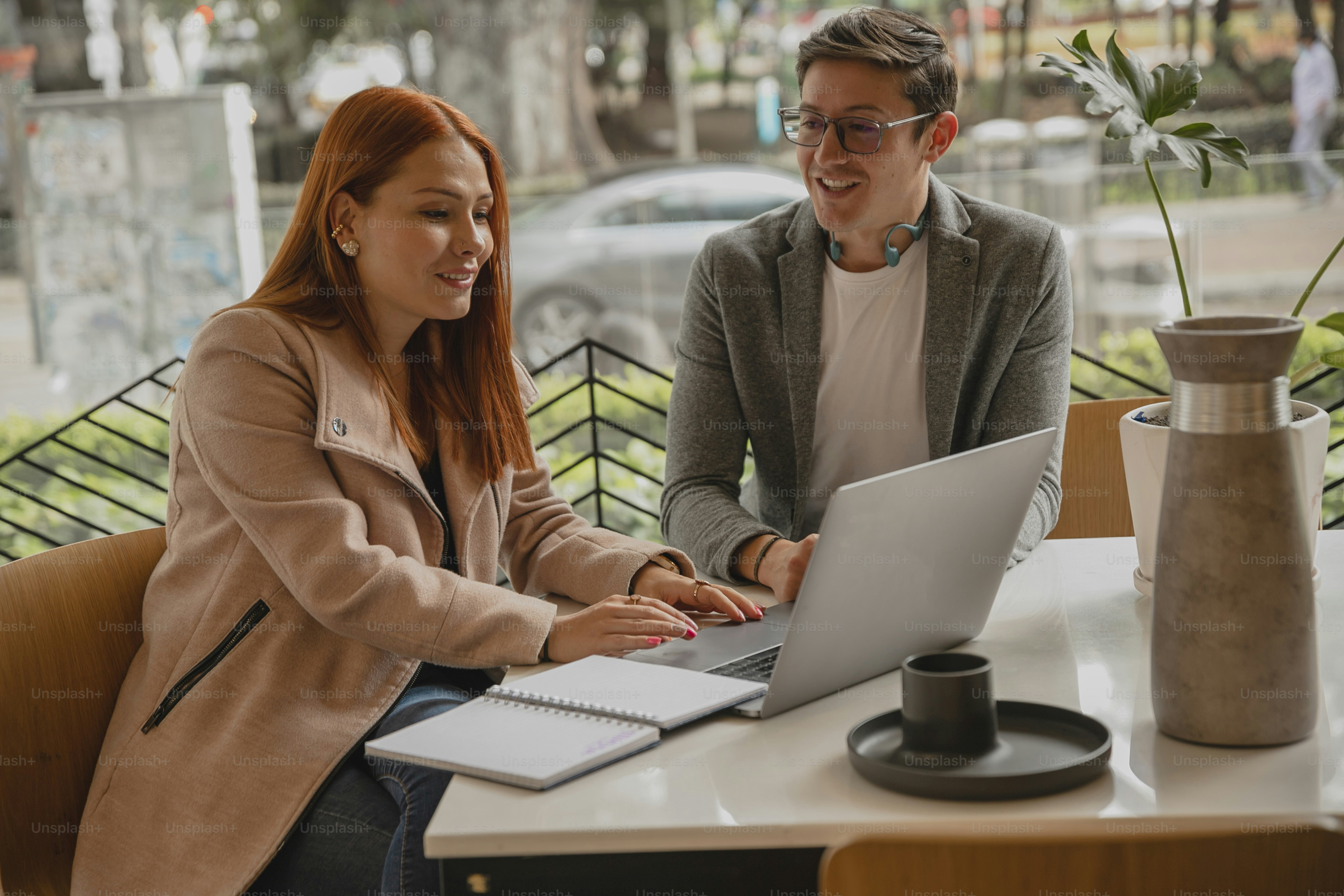 a man and a woman sitting at a table with a laptop