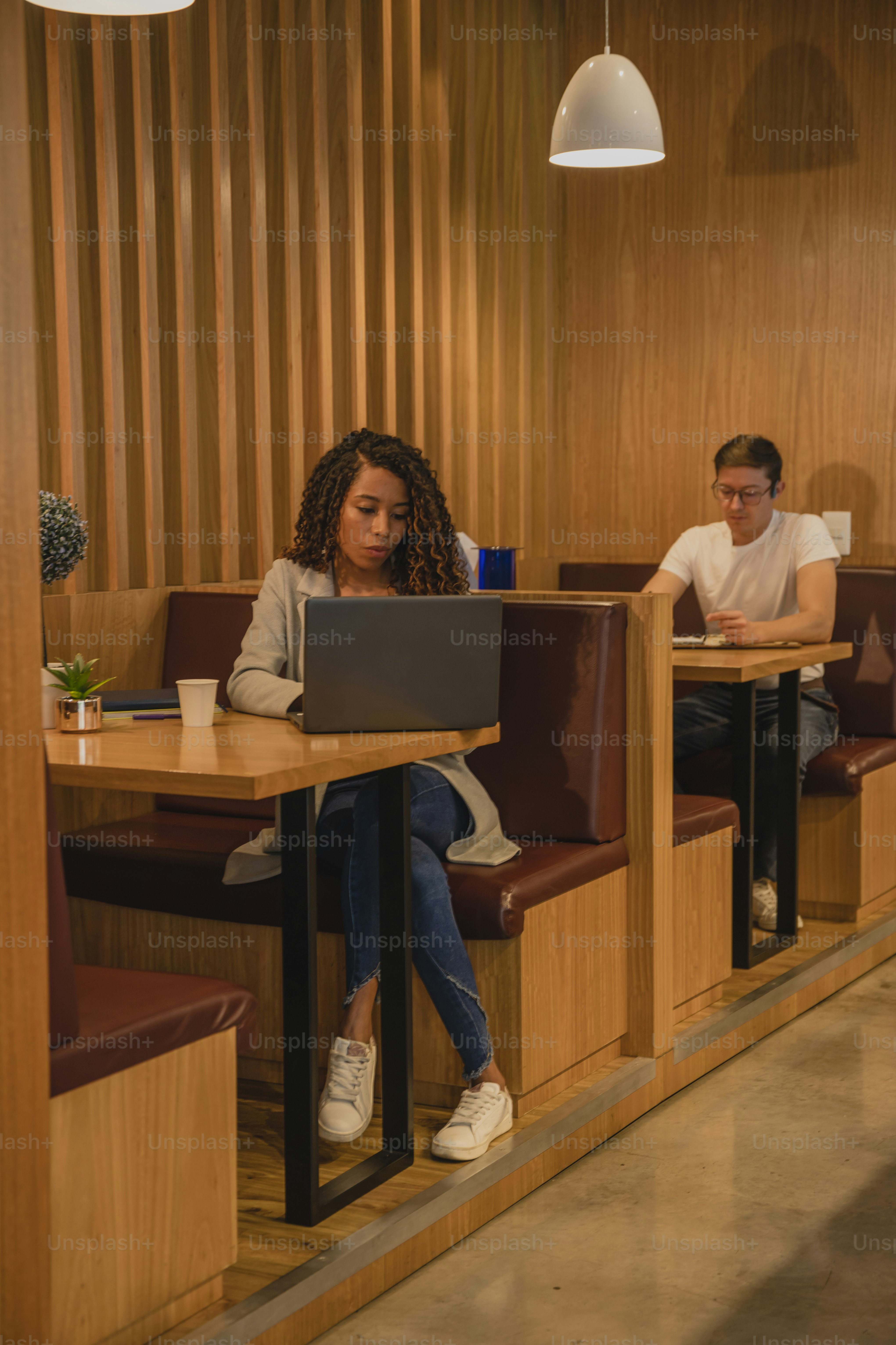 a couple of people sitting at a table with laptops