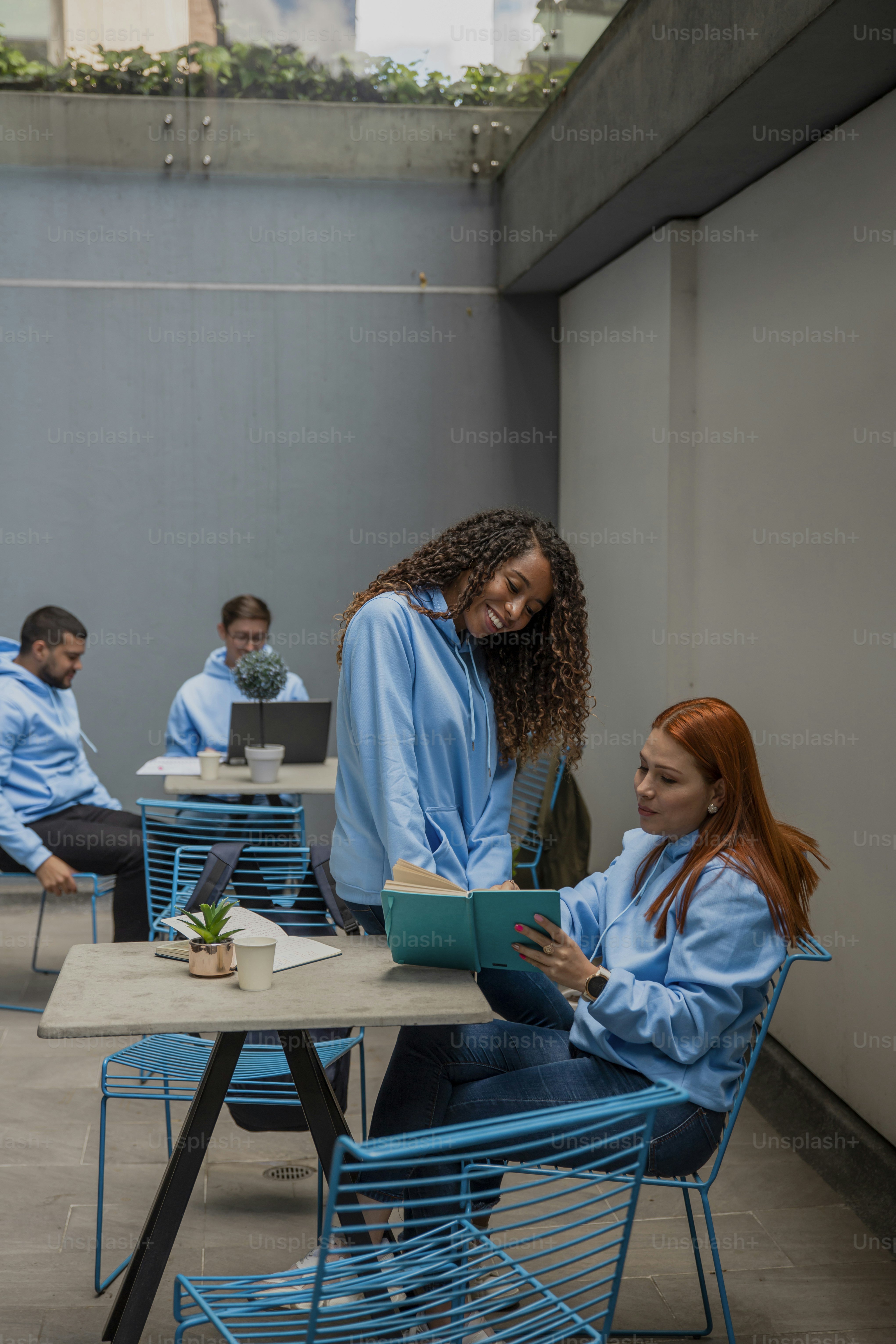 a woman sitting at a table with a book in front of her