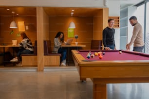 a group of people playing a game of pool