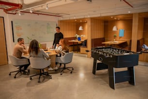 a group of people sitting around a table with foosball