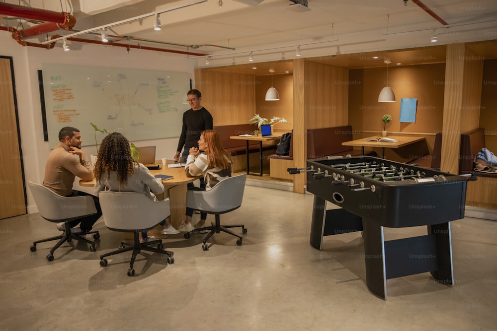 a group of people sitting around a table with foosball