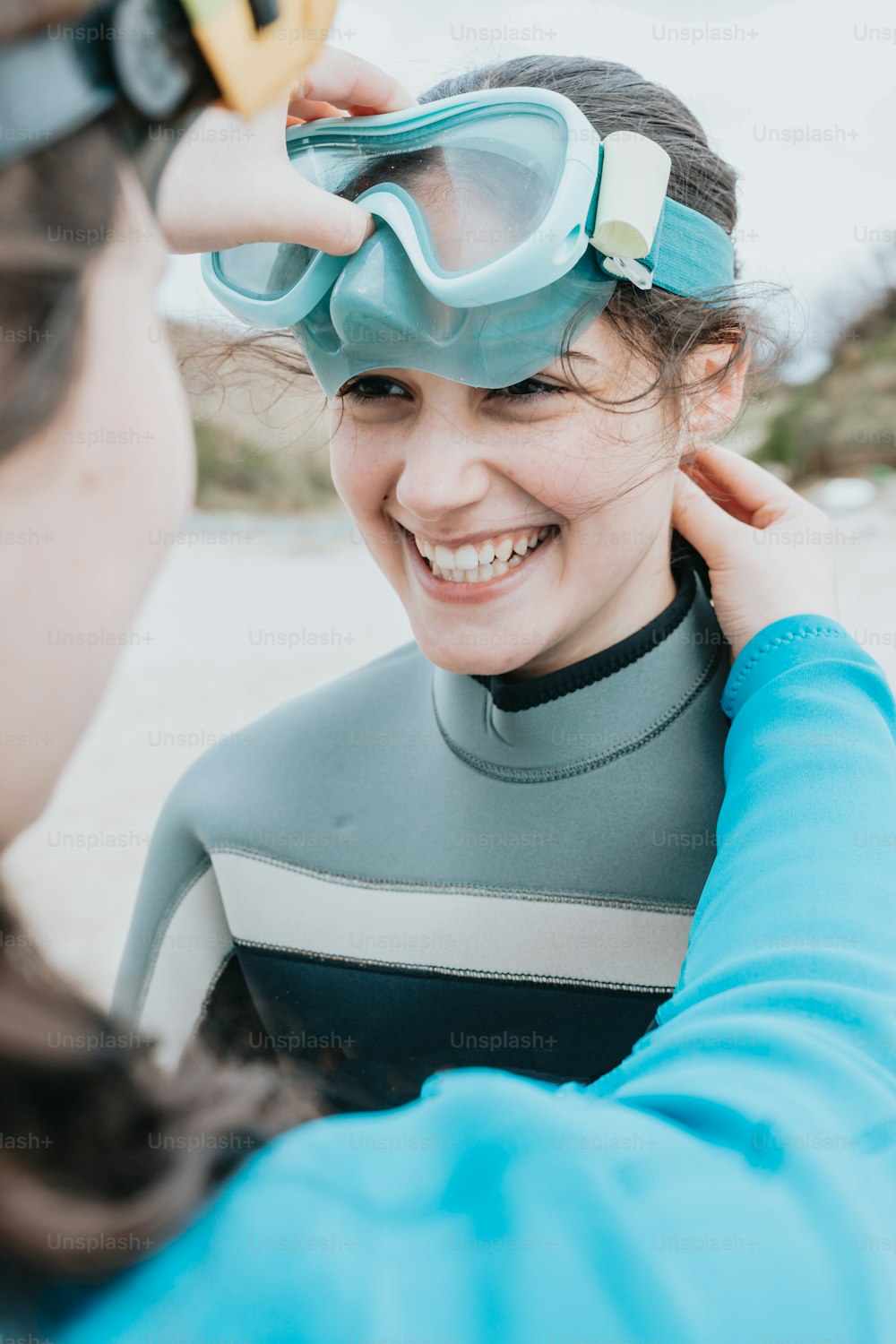 a woman in a wetsuit putting on goggles