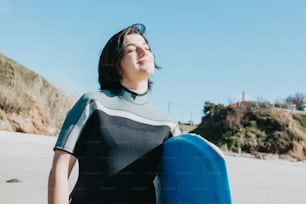 a woman in a wet suit holding a surfboard