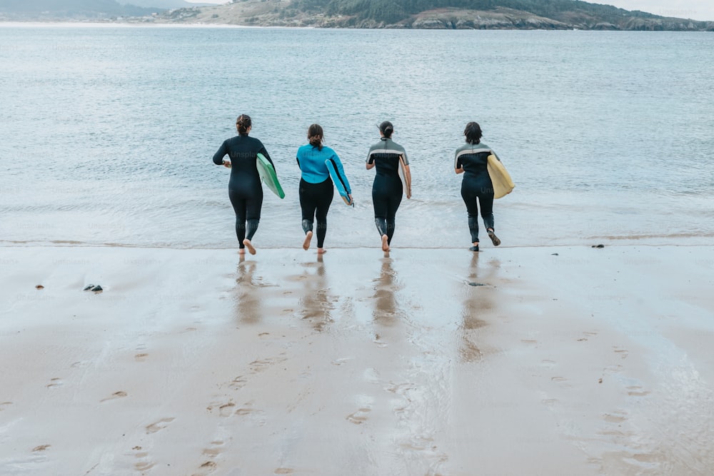 a group of people walking on top of a beach