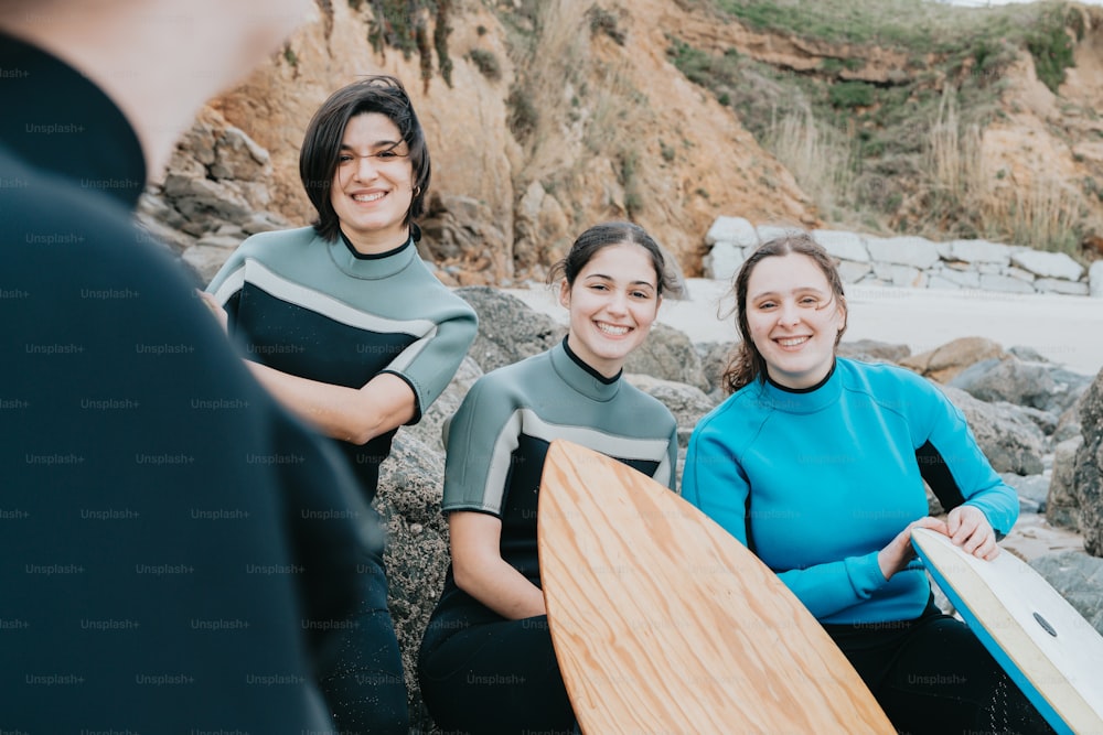 a group of women sitting next to each other holding surfboards