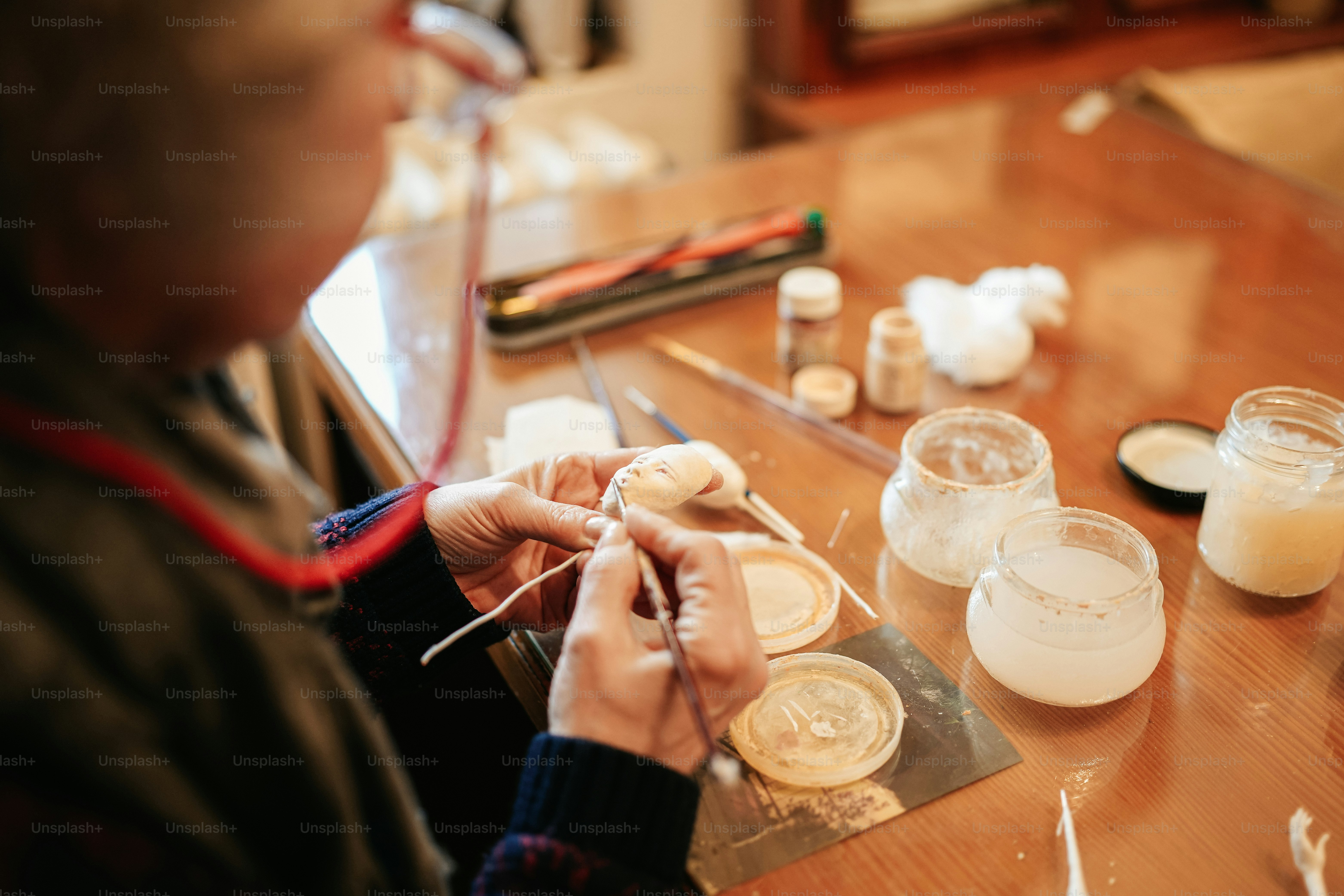 a person sitting at a table working on a piece of art