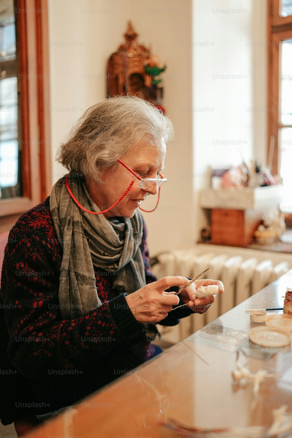 a woman sitting at a table looking at a cell phone