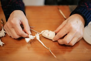 a person holding a piece of garlic on top of a wooden table